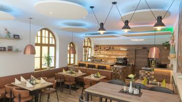 A modern restaurant with wooden tables and chairs, pendant lighting, and a bar area.