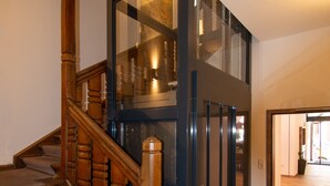 Una escalera moderna con escalones de madera y barandillas de vidrio.