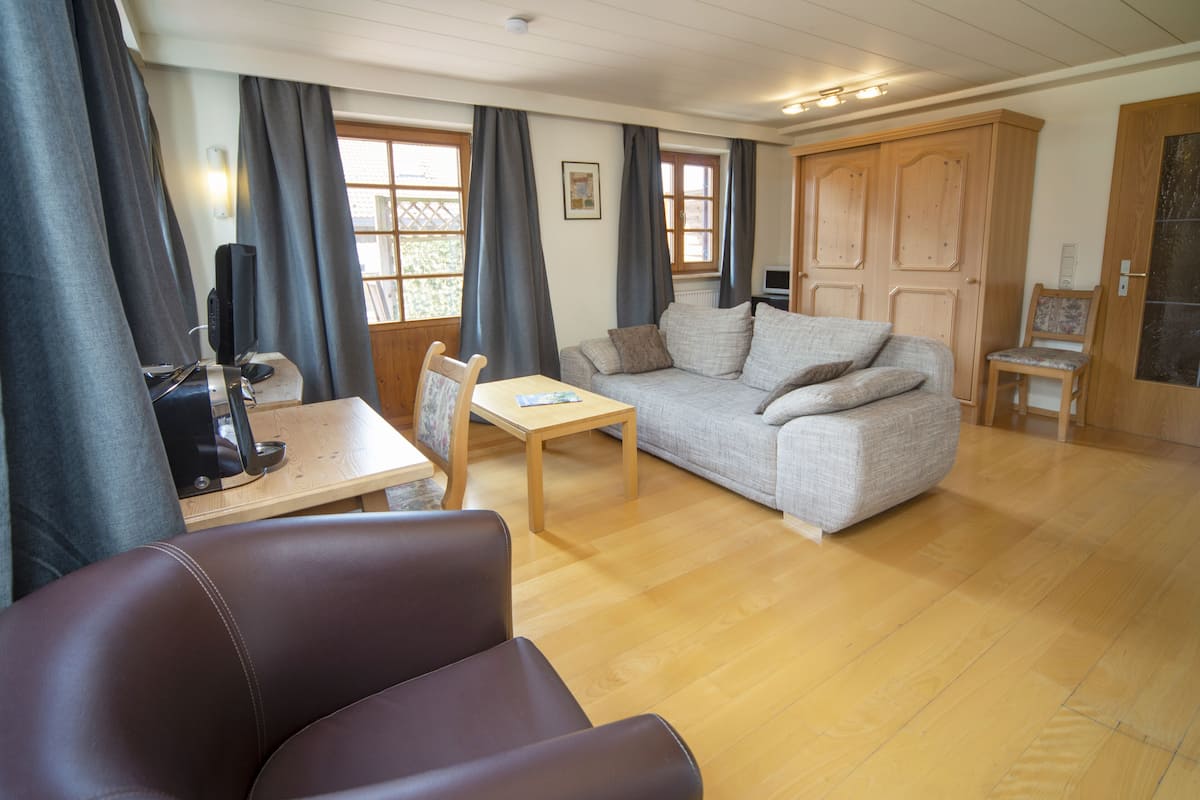 Ein gemütliches Wohnzimmer mit einer Couch, einem Holztisch und einem Fernseher.