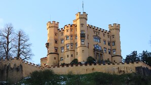 Ein schlossartiges Gebäude mit mehreren Türmen und einer befestigten Mauer.