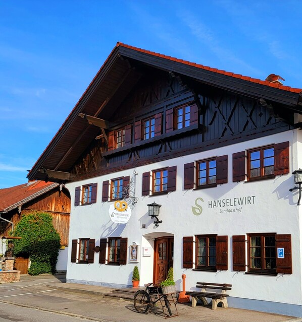 Un bâtiment traditionnel avec une enseigne indiquant : « Hanselewart, auberge de campagne, chambre I ».