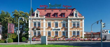 A hotel with a red roof and multiple windows.