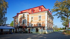Um edifício de vários andares com telhado vermelho, entrada no nível da rua e área externa para sentar.
