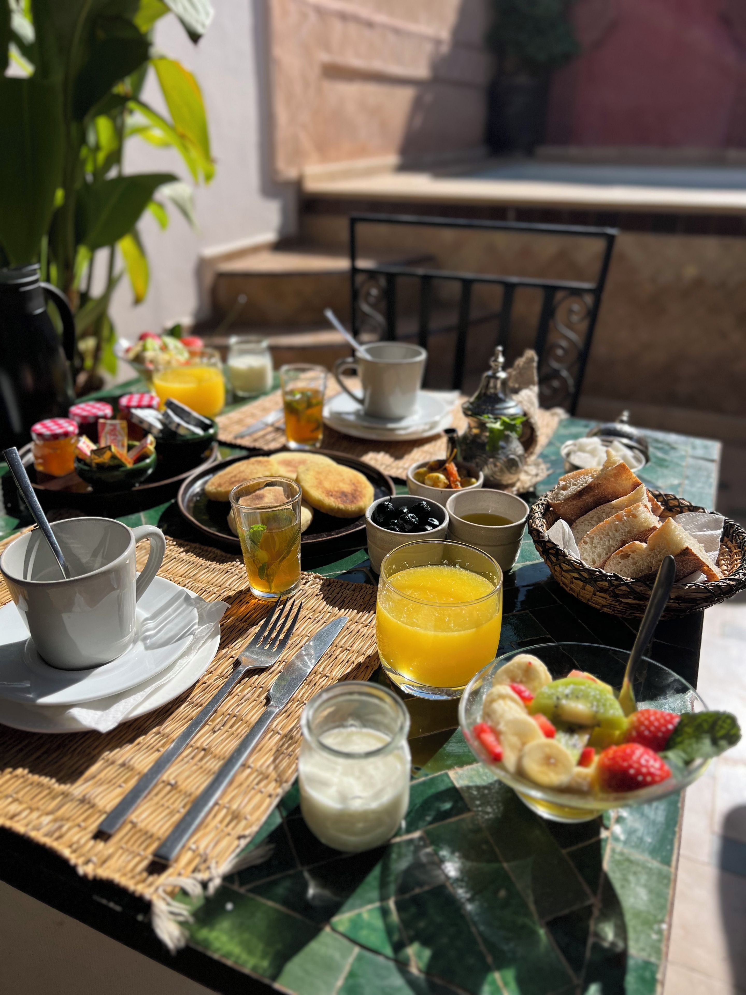A table set with breakfast items including toast, fruit, and beverages.