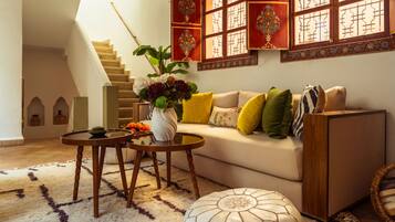 A living room with a sofa, a coffee table, a decorative vase, and a staircase.