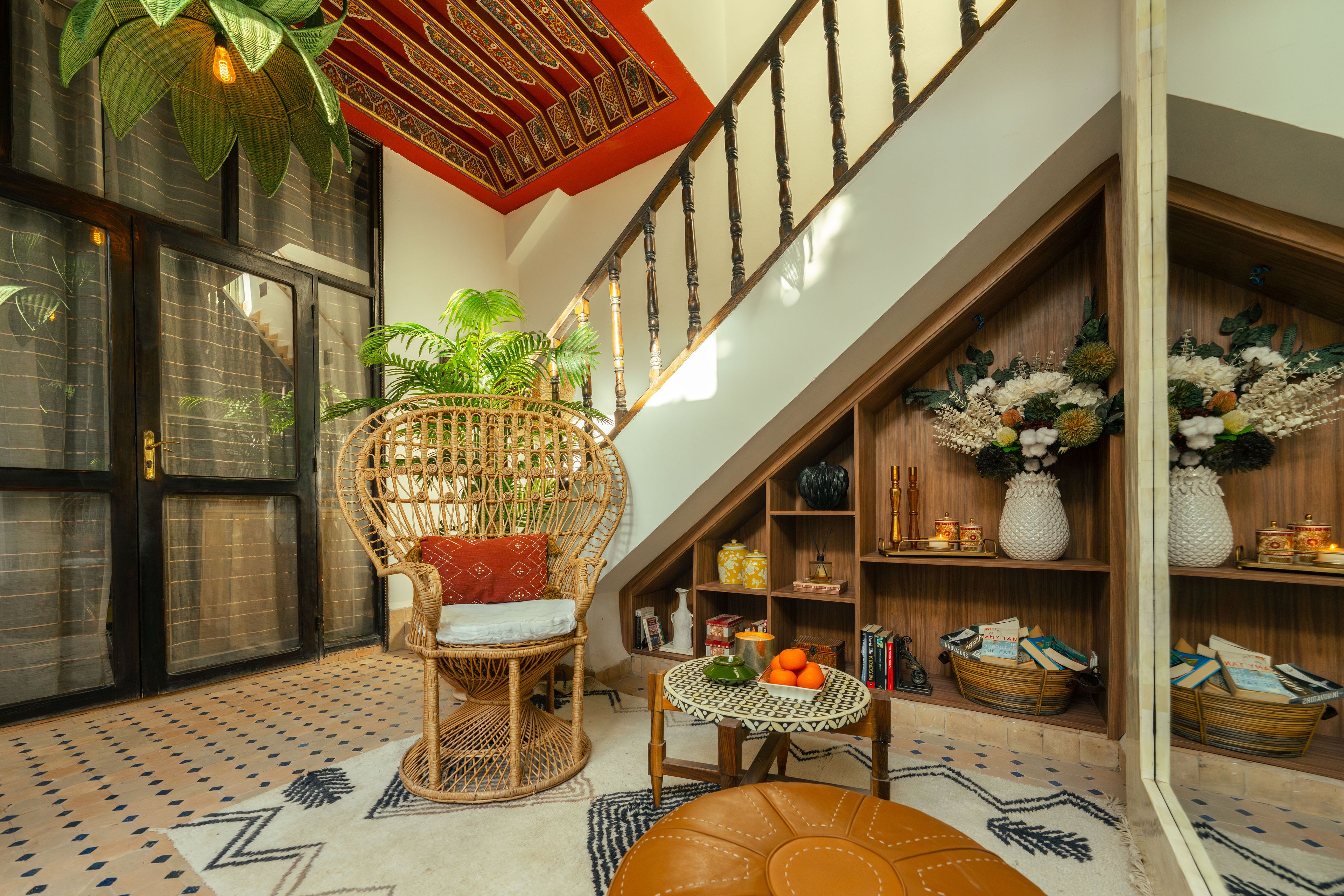 A spacious room with a high ceiling, a staircase, and a large window.