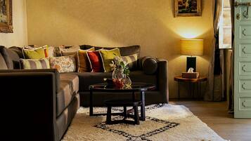 Ein gemütliches Wohnzimmer mit einer Couch, einem Couchtisch und einer Lampe.