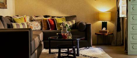 A cozy living room with a sofa, coffee table, and a lamp.