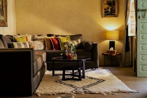 Un salon confortable avec un canapé, une table basse et une lampe.