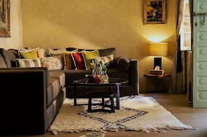 A cozy living room with a sofa, coffee table, and a lamp.