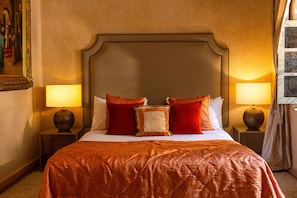 A hotel room with a large bed, two bedside lamps, a framed picture on the wall, and a window with curtains. - Riad Jona (Marrakech)
