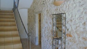 A staircase with a metal railing leading to a room with textured walls and a mirror on the wall. - Gîte des Figourières (Sainte-Anastasie)