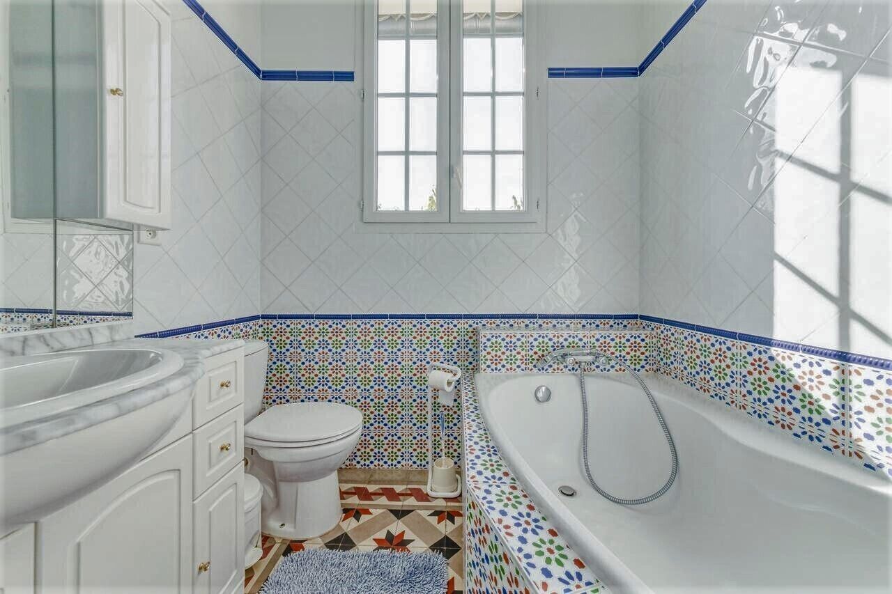 A bathroom with a bathtub, toilet, and vanity.