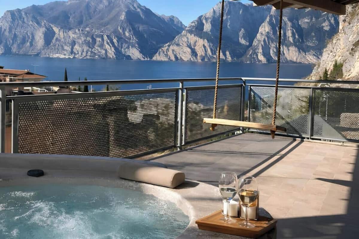 A hot tub with a view of mountains and a body of water.