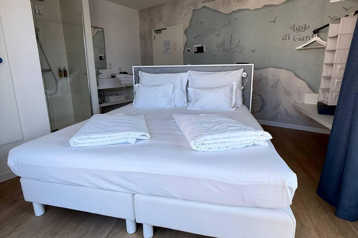 A spacious bedroom with a large bed, a walk-in closet, and a bathroom with a glass shower enclosure.
