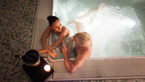 Un bain à remous pour deux personnes, une bouteille de champagne et une bougie.