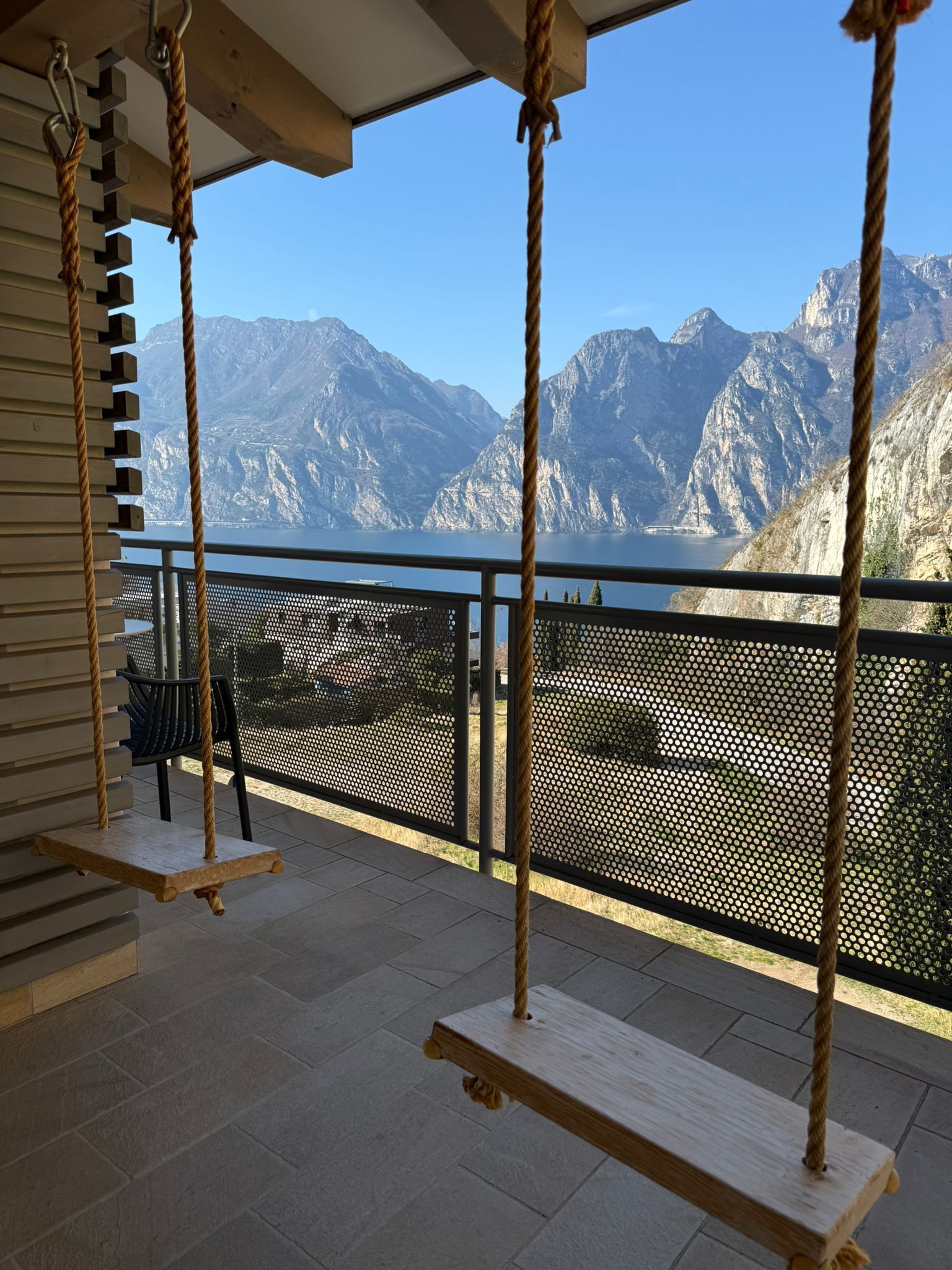 Un balcone con altalene che si affaccia su un lago montano.