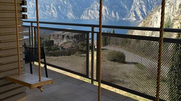 Un balcone con altalene che si affaccia su un lago montano.