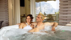 Un couple dans un jacuzzi avec vue sur la montagne.