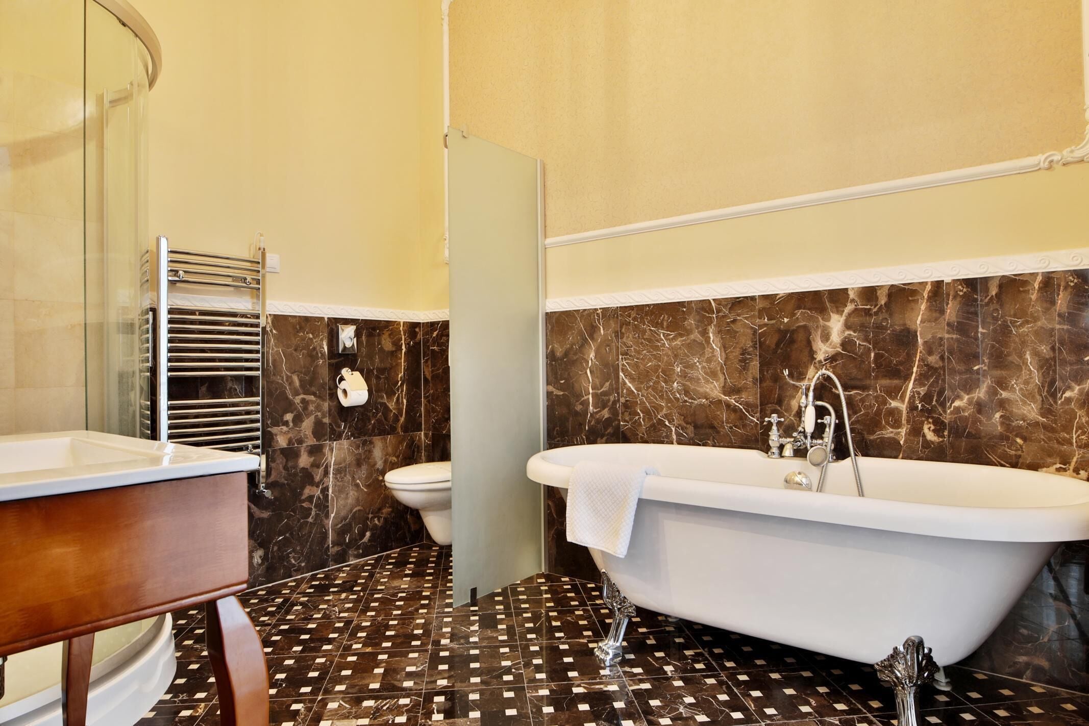 A bathroom with a bathtub, a toilet, and a shower area.