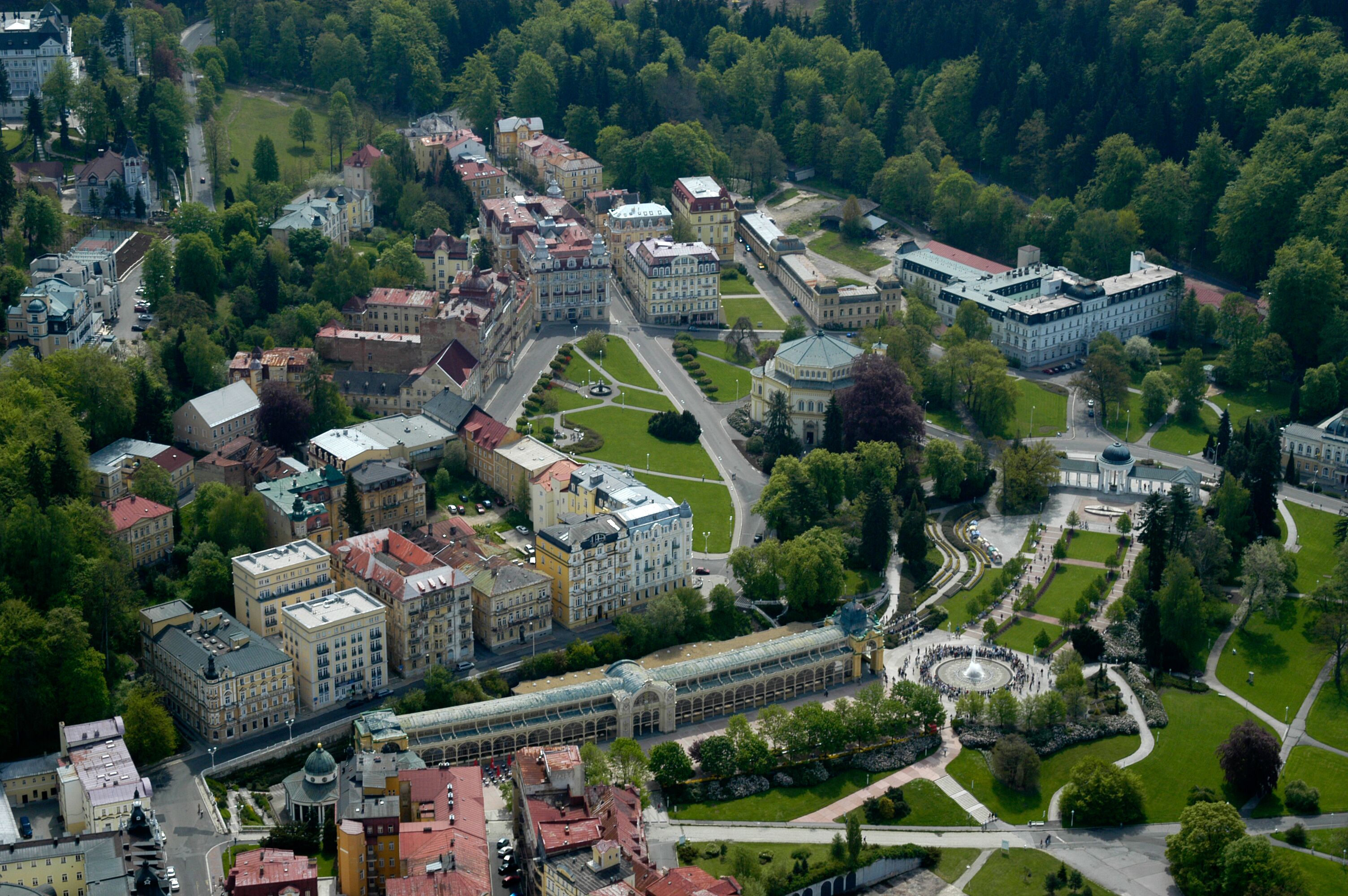 An aerial view of a university campus with multiple buildings, green spaces, and a central circular plaza.