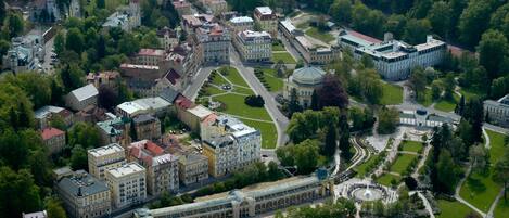 An aerial view of a university campus with multiple buildings, green spaces, and a central circular plaza.