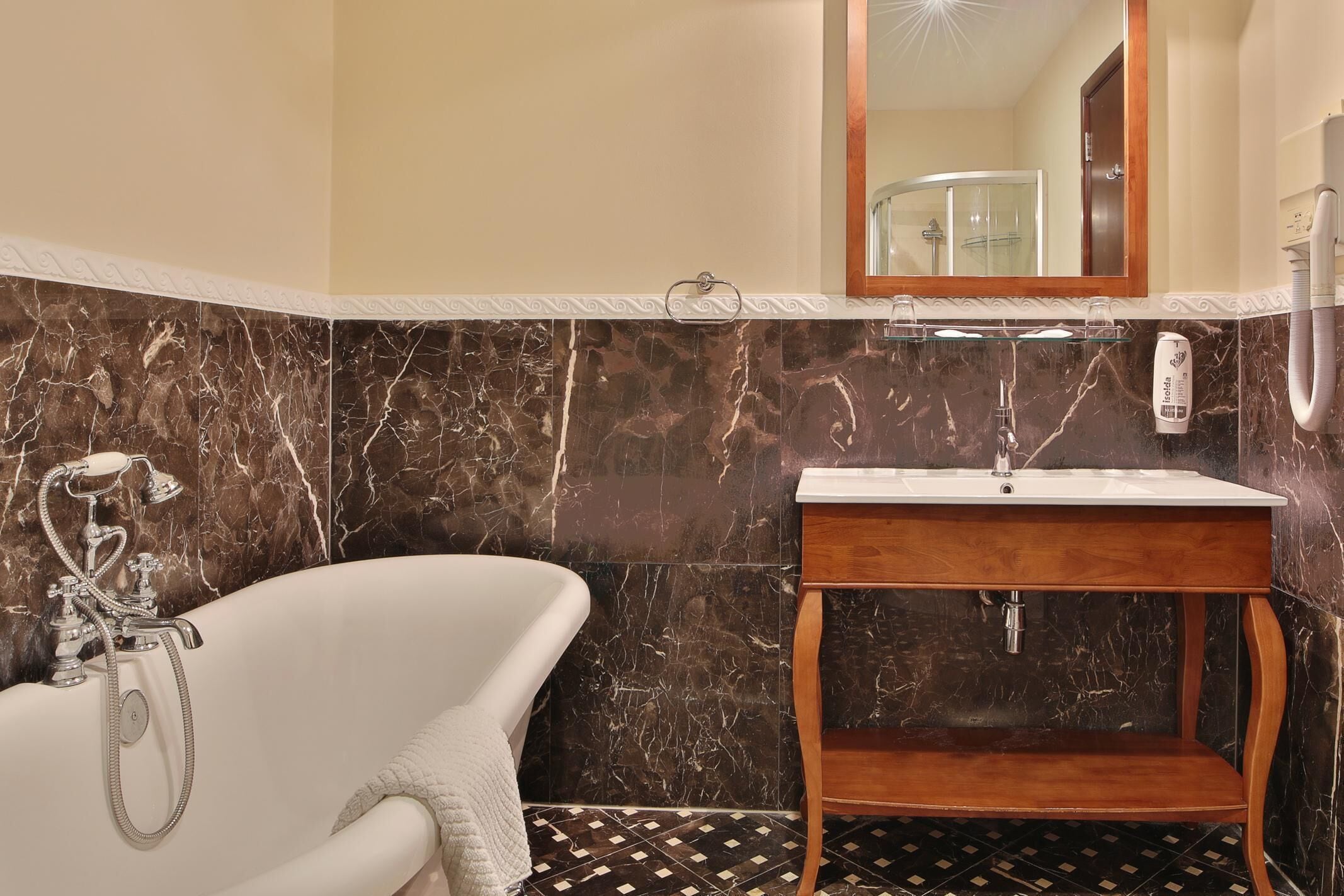 A bathroom with a freestanding bathtub, a wooden vanity with a mirror, and a shower area.