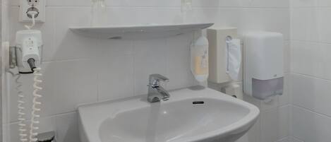 Ein Badezimmer mit Waschbecken, Spiegel und Handtuchhalter.