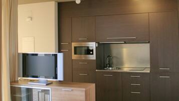 A modern kitchen with a built-in microwave, oven, and sink.