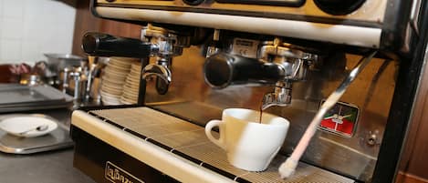 Una cafetera La Bazar preparando una taza de café blanca.