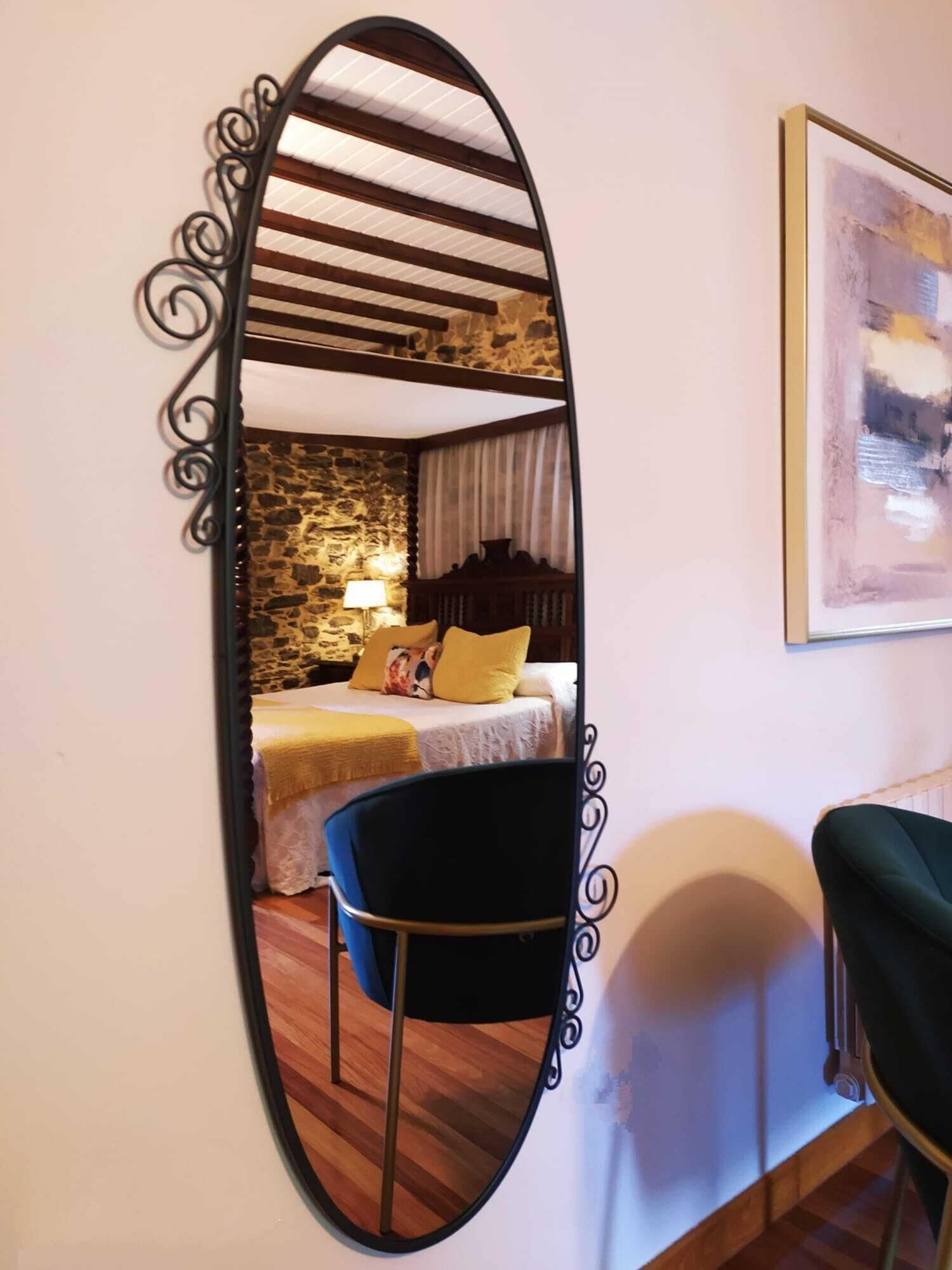 A room with a bed, a chair, a lamp, and a painting on the wall.
