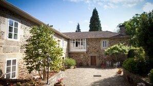 A stone building with a courtyard, stone walls, and potted plants.