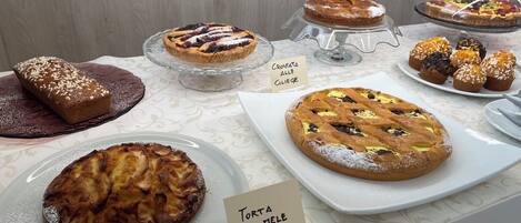 A display of various baked goods including croissants, tarts, and muffins.