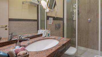 Ein Badezimmer mit Marmorwaschbecken, Spiegel, Handtuchhalter, Dusche und Toilette.
