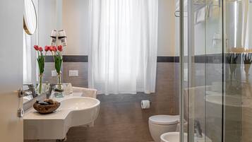 Un bagno moderno con due lavandini, un water e un box doccia in vetro.