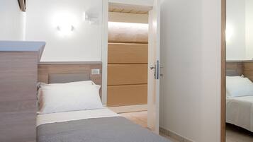 Ein Hotelzimmer mit Bett, Holz-Kopfteil, Nachttisch und Spiegel.