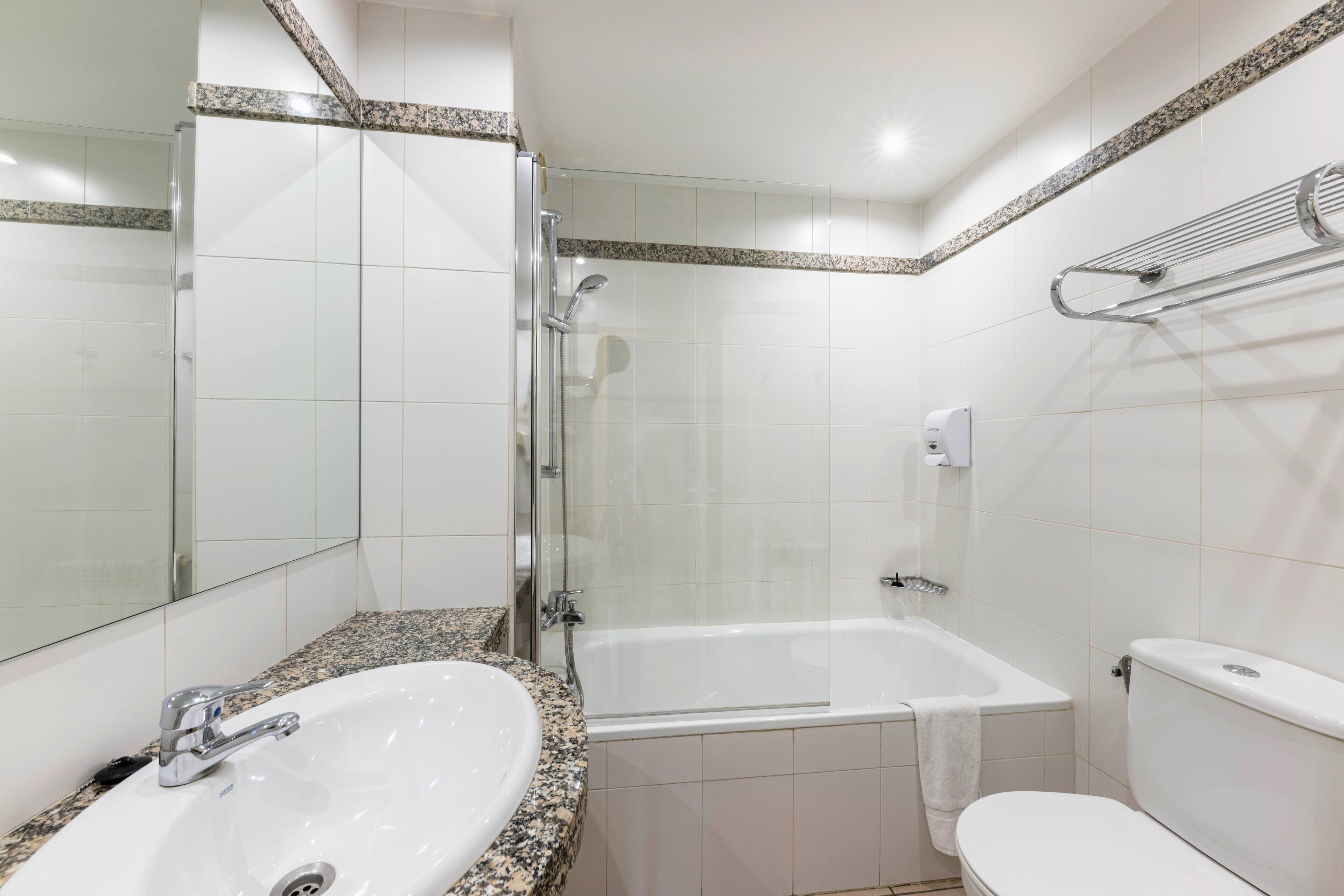 Ein modernes Badezimmer mit einer gläsernen Dusche, einer freistehenden Badewanne und einer weißen Toilette.