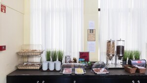 Montaje de un bufé de desayuno con fuentes de comida, máquinas de café y un cartel que dice 'Déjeuner'.