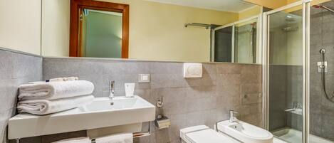 Uma casa de banho moderna com lavatório, sanita e chuveiro.