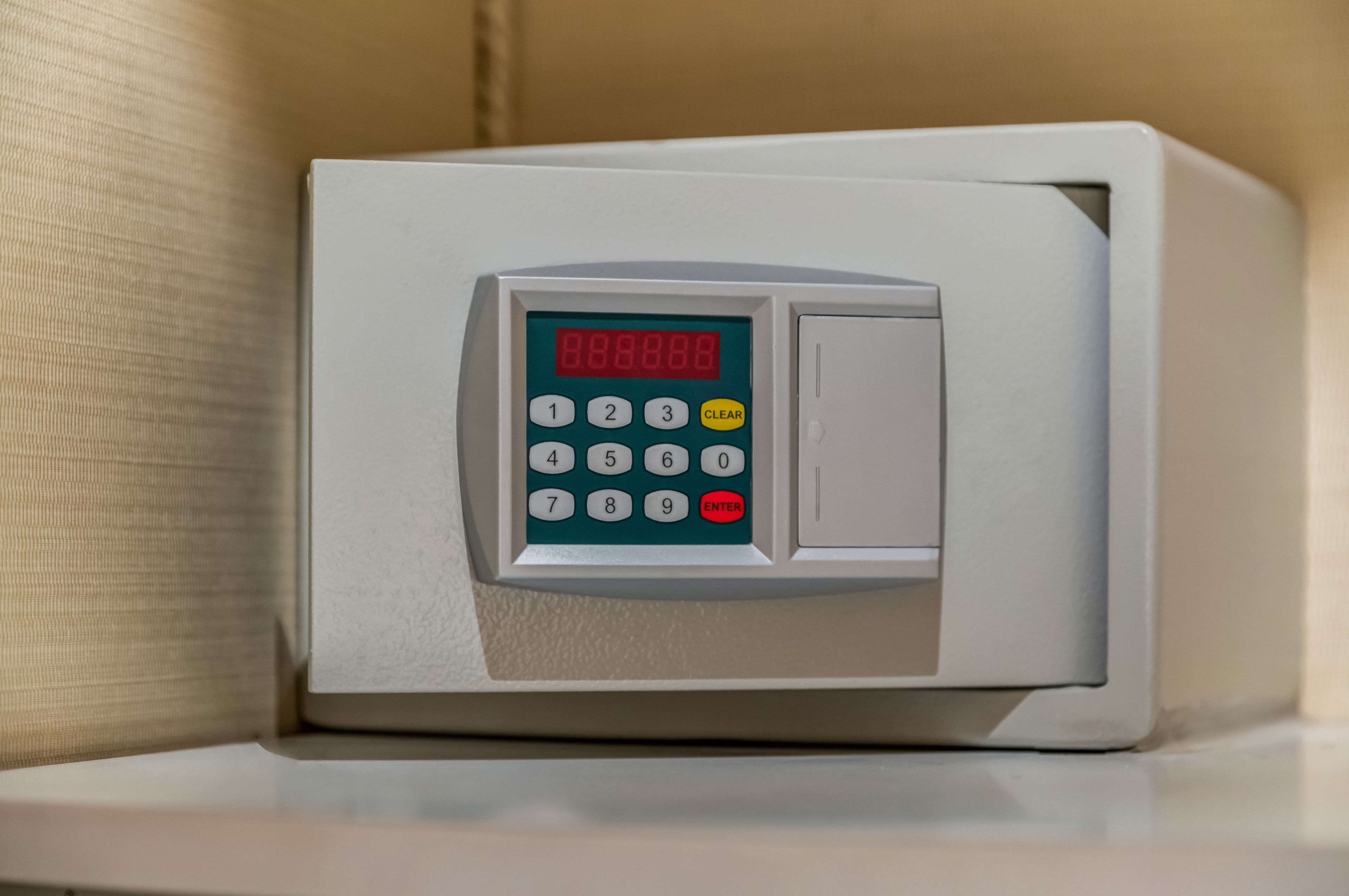 A digital keypad lock on a white cabinet.