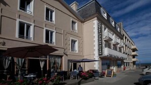 A hotel with multiple balconies, outdoor seating, and a clear view of the sea. - Hotel Alpha Océan (Saint-Malo)