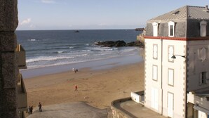 A beach with a building in the foreground. - Hotel Alpha Océan (Saint-Malo)