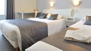 A hotel room with two beds, each with a gray and white bedspread, a nightstand with a lamp, and a view of the outside through a window with curtains. - Hotel Alpha Océan (Saint-Malo)