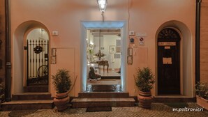 A building entrance with a wrought iron gate, two potted plants, a sign reading "5", and a door labeled "9". - Mondo Antico Alloggio in Città B&B (Cesena)