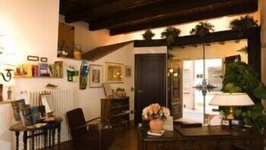 A cozy room with a wooden ceiling, a mirror, a desk with a lamp, and a chair. - Mondo Antico Alloggio in Città B&B (Cesena)