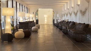 A spacious lobby with a long reception desk, comfortable seating areas, and a clear pathway leading to the exit. - Hotel Mare Pineta (Pula)