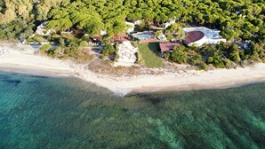 An aerial view of a coastal property with a swimming pool, tennis courts, and a beach. - Hotel Mare Pineta (Pula)