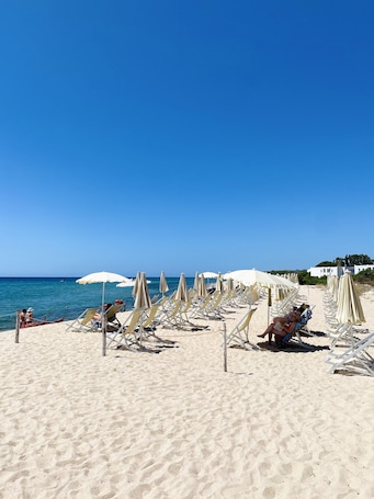 Aan het strand, wit zand, parasols. Hotel Mare Pineta