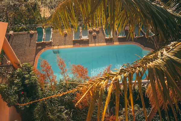 Utomhuspool, parasoller och solstolar