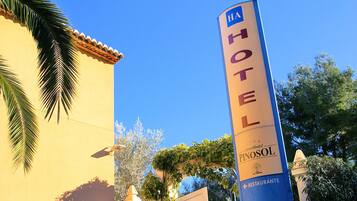 A hotel sign with "HA HOTEL" and "Pinosol" branding, indicating a hotel named Pinosol.
